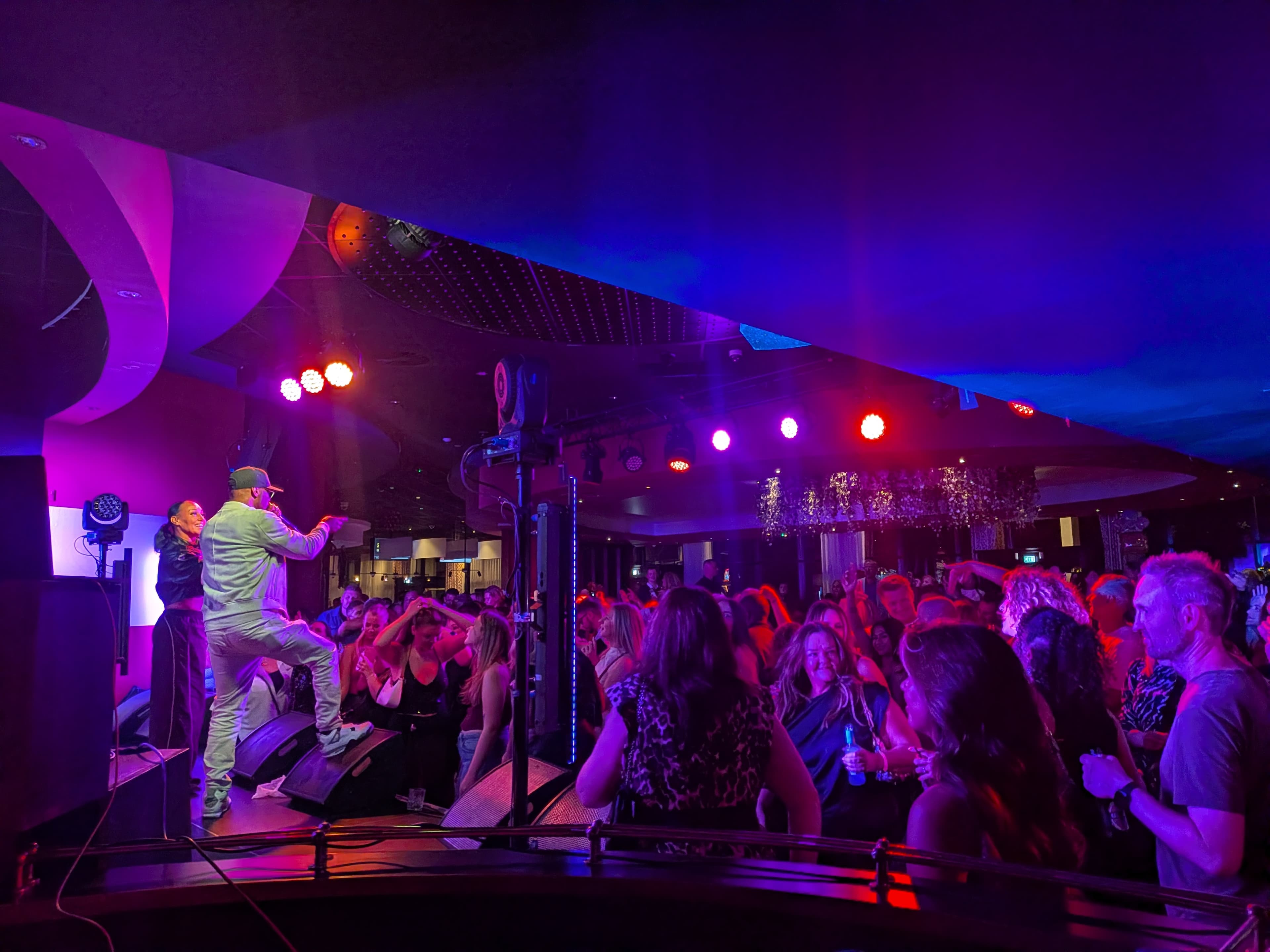 Live band performing under vivid pink and blue stage lights